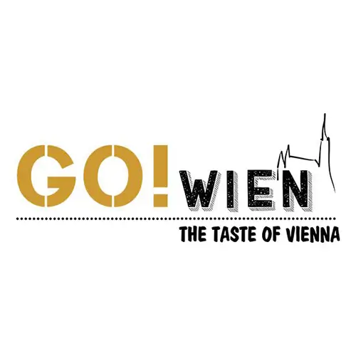 Logo mit dem Schriftzug GO! WIEN in Fettdruck, mit GO! in Gold und WIEN in Schwarz. Darunter befindet sich eine Strichzeichnung eines Wiener Wahrzeichens und der Schriftzug THE TASTE OF VIENNA.