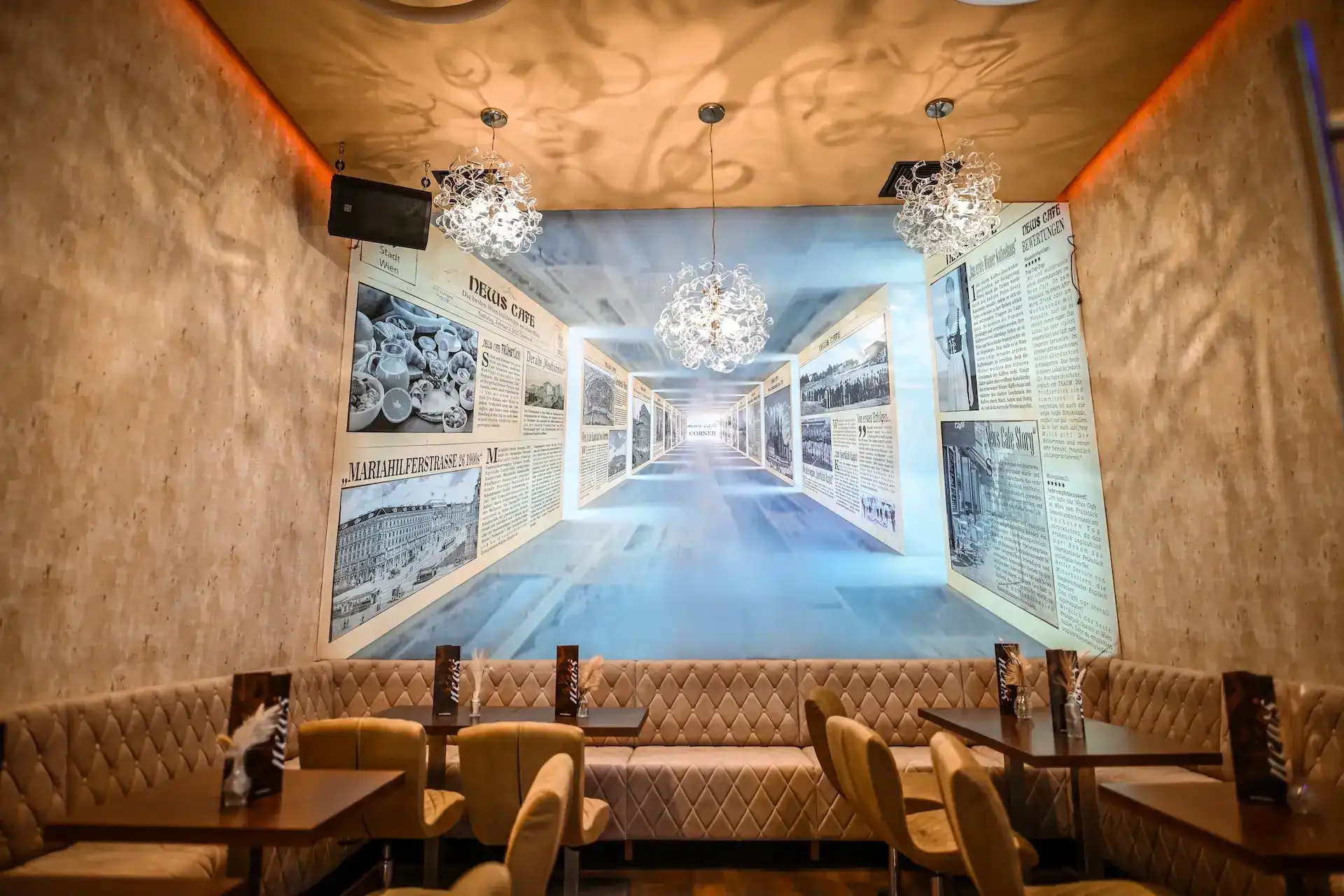 Ein stilvolles Restaurantinterieur mit gepolsterten beigen Sitzen, modernen Stühlen, dunklen Holztischen und verzierten Hängelampen. An der Rückwand befindet sich ein großes Wandgemälde, das an alte Zeitungen erinnert, und ein Flur mit Fluchtpunkt.