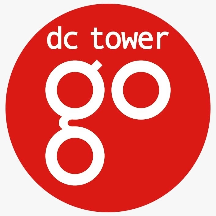 Ein roter Kreis mit weißem Schriftzug „dc tower“ oben und einem großen, stilisierten „go“ in der Mitte. Die Buchstaben sind abgerundet und fett gedruckt.
